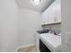 Functional laundry room with white cabinets, modern washer and dryer, and tile flooring at 433 Village Bend Dr, Fuquay Varina, NC 27526