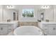 This elegant main bathroom features a soaking tub, double vanity and lots of natural light at 433 Village Bend Dr, Fuquay Varina, NC 27526