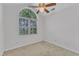 Bright bedroom featuring a ceiling fan and a large window offering natural light at 4825 Windbreak Ln, Raleigh, NC 27616