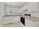 Functional white kitchen with matching appliances, countertops, and cabinetry provides a clean and cohesive space at 4825 Windbreak Ln, Raleigh, NC 27616