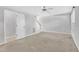 Spacious living room features neutral carpet, ceiling fan and ample natural light with a door to a half bath at 4825 Windbreak Ln, Raleigh, NC 27616