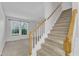Carpeted staircase with white railings and wood accents leads to the upper level, connecting the entryway and living room at 4825 Windbreak Ln, Raleigh, NC 27616