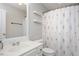 Bathroom with white vanity, floral shower curtain, and decorative floating shelves at 4826 Sir Duncan Way, Raleigh, NC 27612