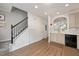 Bright hallway with hardwood floors, a staircase, and a view into the kitchen at 4826 Sir Duncan Way, Raleigh, NC 27612