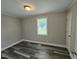 Clean bedroom with sleek gray flooring, white trim, and abundant natural light from a window at 511 Commonwealth St, Durham, NC 27703
