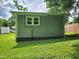 View of the exterior of the home with green siding, a small white framed window, and a green lawn at 511 Commonwealth St, Durham, NC 27703