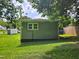 Side view of the home's green siding, a white framed window, and bright green grass at 511 Commonwealth St, Durham, NC 27703