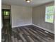 Bright living room with new dark wood-look floors and neutral wall paint, featuring a large window at 511 Commonwealth St, Durham, NC 27703