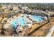 Aerial view of a resort-style community pool with kiddie slides, seating, and a clubhouse at 518 Emerald Downs Rd, Cary, NC 27519