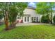 A spacious backyard featuring a patio, green grass, a mature shade trees and an outdoor seating area at 518 Emerald Downs Rd, Cary, NC 27519