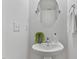 Small powder room features pedestal sink, round mirror, and convenient towel rack at 518 Emerald Downs Rd, Cary, NC 27519