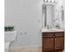 Bright bathroom featuring a wooden vanity with marble countertop and beige tile floors at 518 Emerald Downs Rd, Cary, NC 27519
