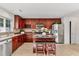 Spacious kitchen featuring stainless steel appliances, an island with barstool seating, and warm wooden cabinetry at 518 Emerald Downs Rd, Cary, NC 27519