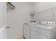 A functional laundry room featuring a washer, dryer, shelving, and tile floors at 518 Emerald Downs Rd, Cary, NC 27519
