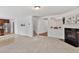 Comfortable living room with a fireplace, neutral carpet, and smooth flow into kitchen and stairway at 518 Emerald Downs Rd, Cary, NC 27519