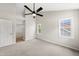 Bright bedroom with ceiling fan, neutral carpet and paint, and natural light from two windows at 5317 Peacenest Dr, Raleigh, NC 27610