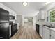 Spacious kitchen features black appliances, bright white cabinets, and laminate flooring at 5317 Peacenest Dr, Raleigh, NC 27610