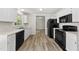 Kitchen boasts wood floors, black appliances, and white cabinets at 5317 Peacenest Dr, Raleigh, NC 27610