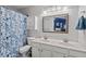 Bathroom featuring dual sinks, a large mirror, vanity, and a shower/tub combo with a blue patterned shower curtain at 5505 Heather Garden Way, Raleigh, NC 27613