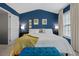 Bright bedroom with blue accent wall, white bedding, and plenty of natural light from the window at 5505 Heather Garden Way, Raleigh, NC 27613