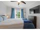 A comfortable bedroom with a ceiling fan, a flat-screen TV, and a view to the outside at 5505 Heather Garden Way, Raleigh, NC 27613
