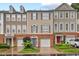 Charming townhome with brick and beige siding, complemented by a well-manicured front yard and attached garages at 5505 Heather Garden Way, Raleigh, NC 27613