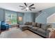 Bright living room with large window, plush gray sofa, and stylish decor, offering a relaxing atmosphere at 5505 Heather Garden Way, Raleigh, NC 27613