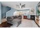 Cozy living room with blue walls, a ceiling fan, a fireplace, and a comfortable gray sectional couch at 5505 Heather Garden Way, Raleigh, NC 27613