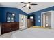 Large main bedroom with ensuite bathroom, blue walls, high ceilings, plush carpet, and dark wood furniture at 5505 Heather Garden Way, Raleigh, NC 27613