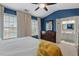 This main bedroom features blue walls, plush carpeting, large windows with white curtains, and dark wood furniture at 5505 Heather Garden Way, Raleigh, NC 27613