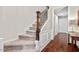 Carpeted staircase with wooden handrail and white trim, leading to the upper level of the home at 5505 Heather Garden Way, Raleigh, NC 27613