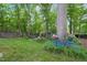 Lush backyard featuring mature trees, landscaped garden beds, and charming decorative bicycle at 5523 Newberry Dr, Raleigh, NC 27609