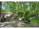 Inviting backyard patio featuring a lounge chair and dining set, surrounded by mature trees at 5523 Newberry Dr, Raleigh, NC 27609