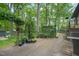 A backyard patio featuring potted plants and an arbor with mature trees in the background at 5523 Newberry Dr, Raleigh, NC 27609