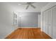 Bright bedroom featuring hardwood floors, a ceiling fan, and a window with natural light at 5523 Newberry Dr, Raleigh, NC 27609