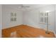 Inviting bedroom featuring hardwood floors, a ceiling fan, and large windows with natural light at 5523 Newberry Dr, Raleigh, NC 27609