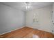 Cozy bedroom with hardwood floors, a ceiling fan, and a window with natural light at 5523 Newberry Dr, Raleigh, NC 27609