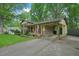 Traditional brick home with covered parking, American flag, and mature landscaping at 5523 Newberry Dr, Raleigh, NC 27609