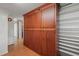Hallway featuring beautiful wood-look flooring, a closet with wooden doors, and shelving at 5523 Newberry Dr, Raleigh, NC 27609