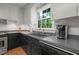 Bright kitchen featuring light gray countertops, stainless appliances, and a large window overlooking the backyard at 5523 Newberry Dr, Raleigh, NC 27609