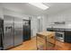 Bright kitchen featuring stainless steel appliances, hardwood floors, and an island with storage at 5523 Newberry Dr, Raleigh, NC 27609