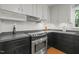 Kitchen featuring stainless steel stove and black countertops, complemented by white subway tile backsplash at 5523 Newberry Dr, Raleigh, NC 27609
