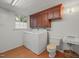 Functional laundry area includes a washer, dryer, toilet, sink, and built-in wooden cabinets for ample storage space at 5523 Newberry Dr, Raleigh, NC 27609
