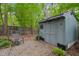 Cozy shed in a shady backyard with gravel, chair, and greenery at 5523 Newberry Dr, Raleigh, NC 27609