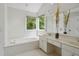 Bright bathroom with soaking tub, double vanity, and large window with a view at 5809 N Hawthorne Way, Raleigh, NC 27603