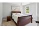 Cozy bedroom with a chandelier, painting, and a wood-framed bed with plush white bedding at 5809 N Hawthorne Way, Raleigh, NC 27603