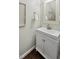 Stylish half bath featuring a white vanity, framed mirror, and decorative artwork at 5809 N Hawthorne Way, Raleigh, NC 27603