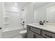 Well-lit bathroom with a shower-tub combination, grey vanity and modern finishes at 70 Noble Heart Pl, Fuquay Varina, NC 27526