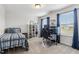 Bright bedroom featuring a metal bed frame, a modern computer setup, and light-filled windows at 70 Noble Heart Pl, Fuquay Varina, NC 27526