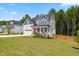 Charming two-story home with a covered porch, red door, and perfectly manicured lawn at 70 Noble Heart Pl, Fuquay Varina, NC 27526